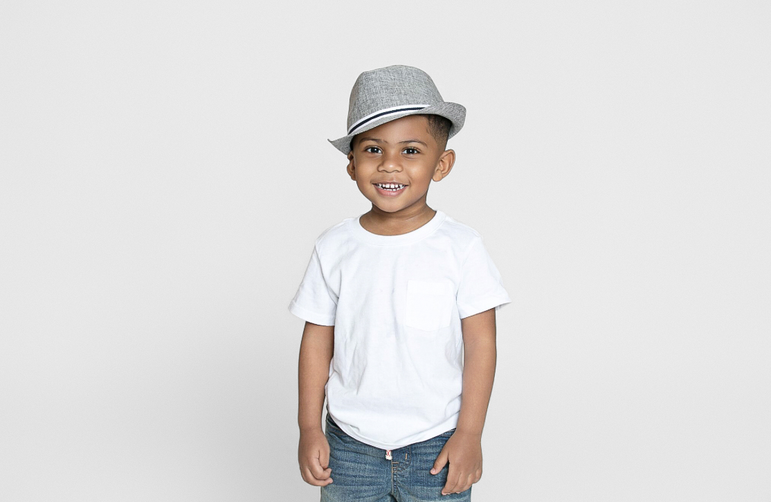 Boy in a gray hat standing and smiling