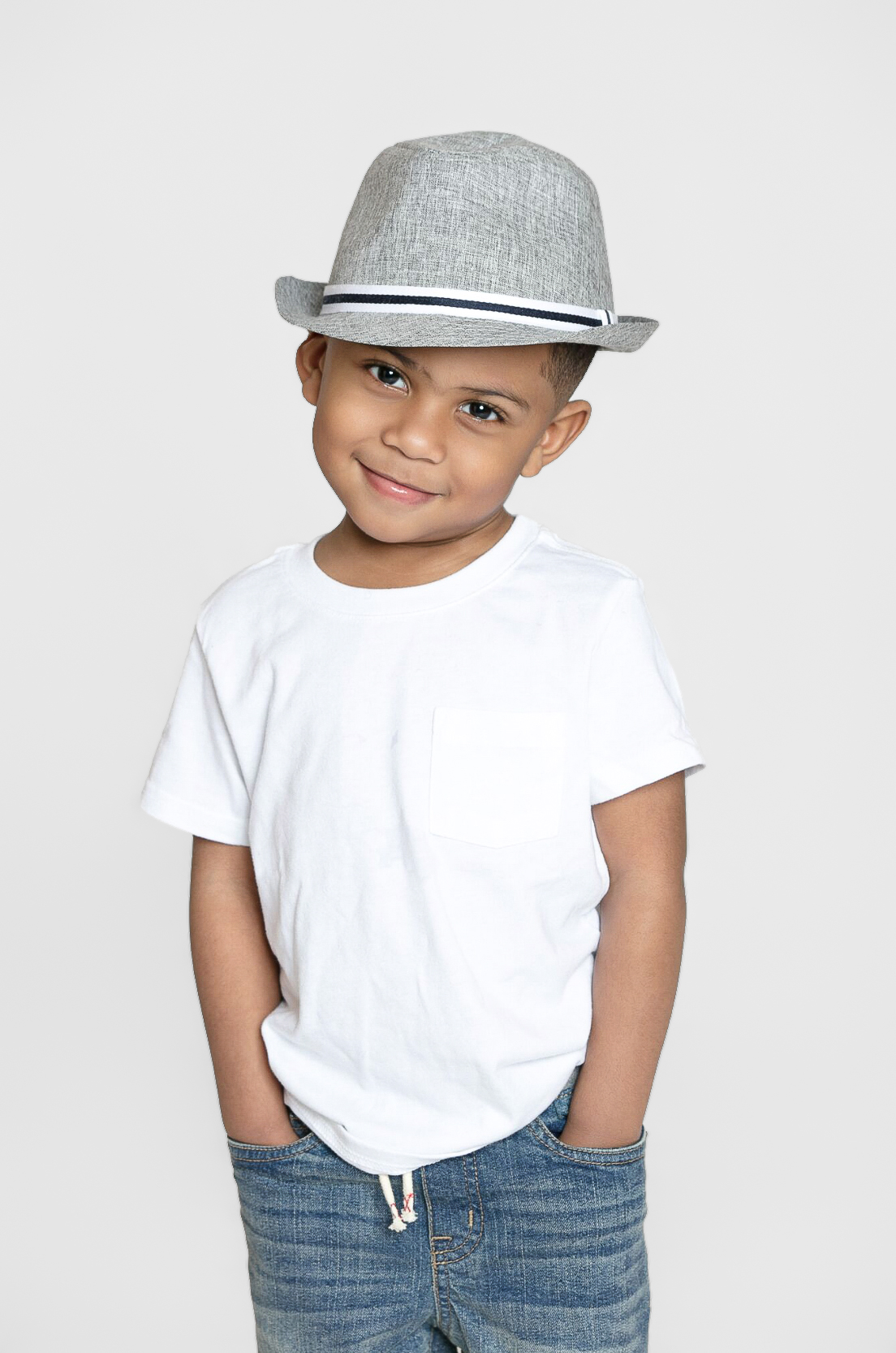 Smiling boy in a gray hat with hands in pockets